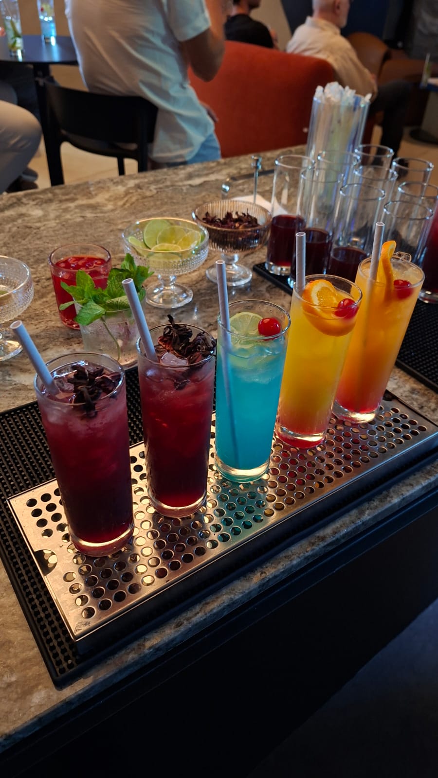 Mocktails de distintos colores servidos sobre una barra de bebidas