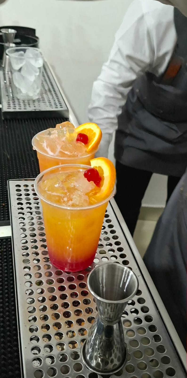 Dos mocktails de tonos naranja y rojo decorados con rodajas de naranja